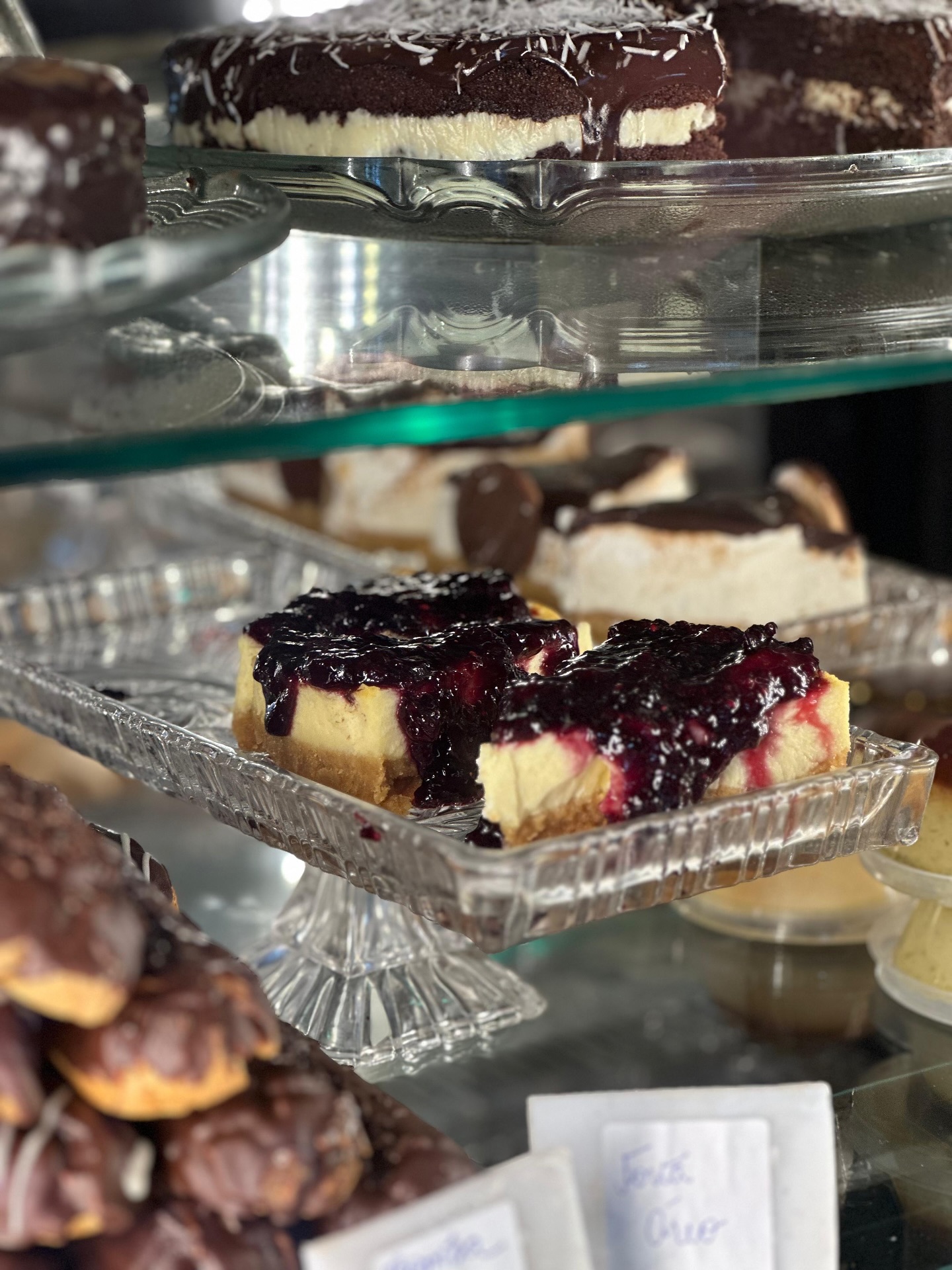 Fatias de cheesecake com calda de frutas vermelhas na vitrine